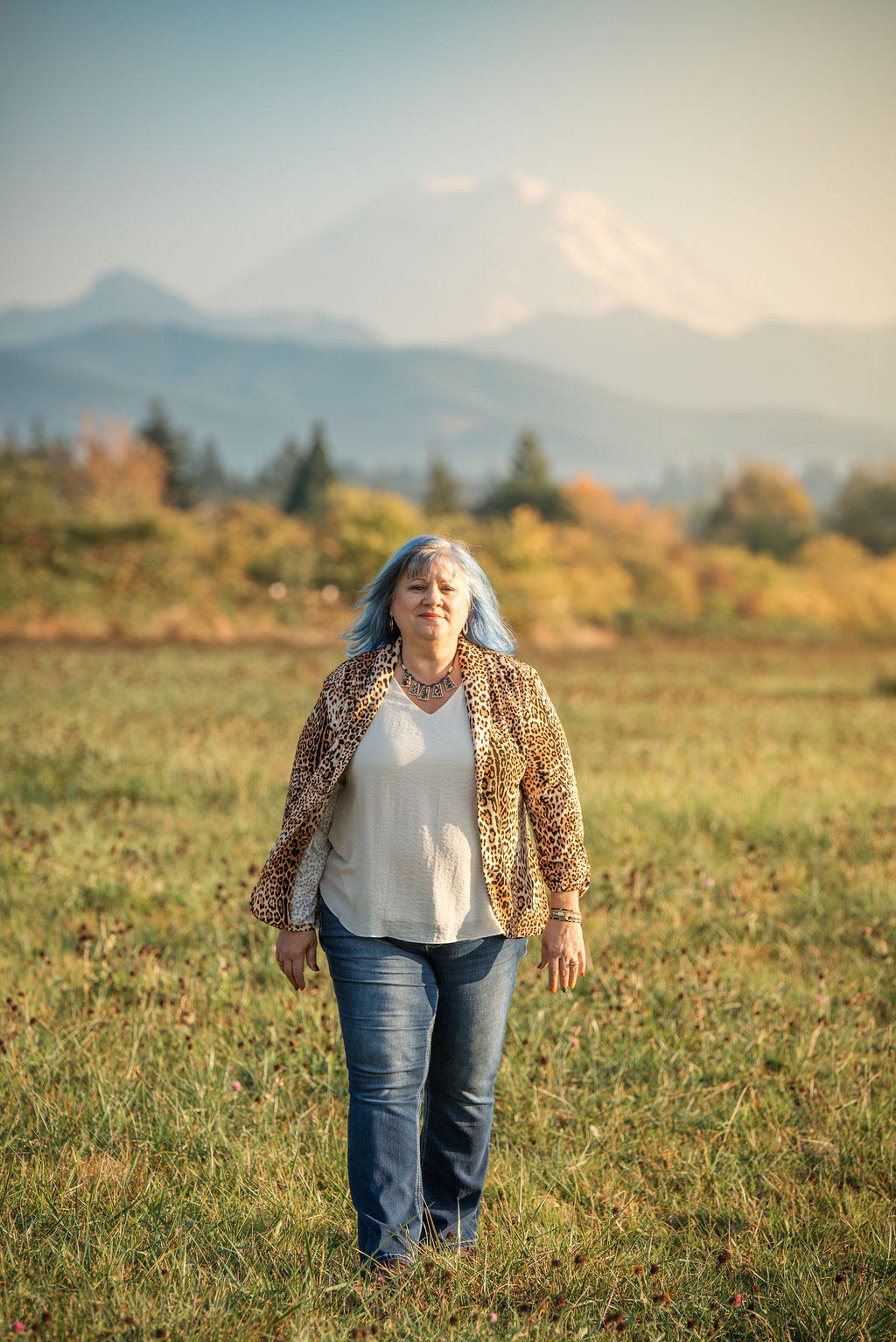 Eva walking through a meadow with mountains in the distance